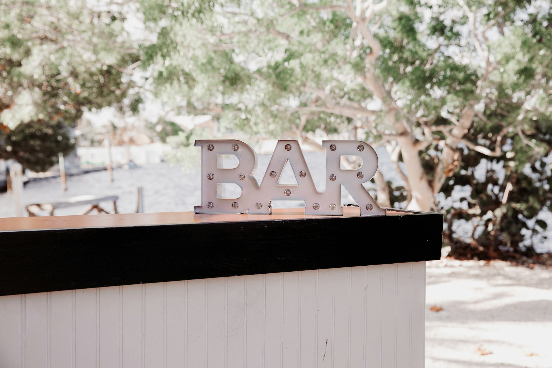 Outdoor cocktail bar with illuminated BAR letters