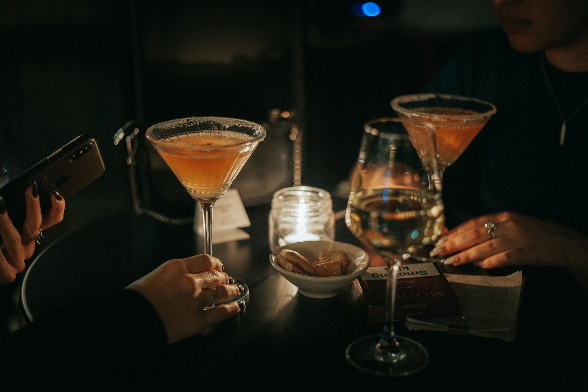 Friends toasting with cocktails at a dinner party